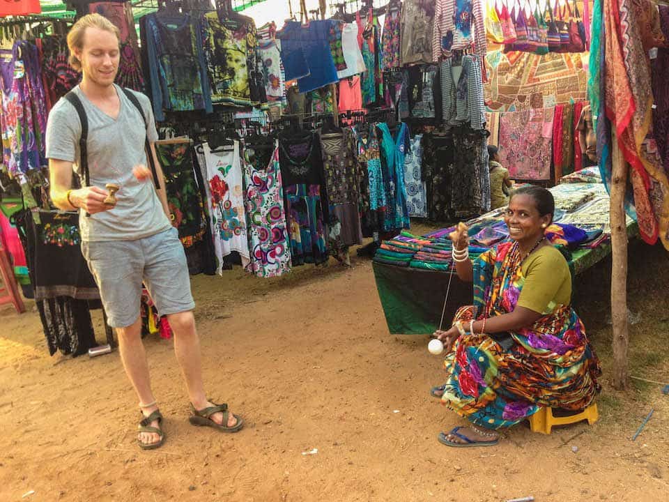 Brandon showing an Indian vendor how to play with the kendama we brought from home