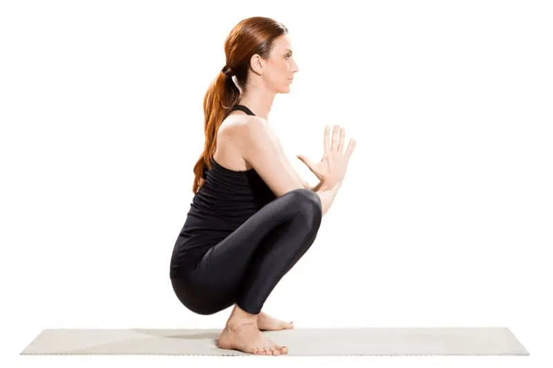 Proper alignment in Prayer Pose includes a long spine, with the shoulders stacked over the hips and heels on the ground.