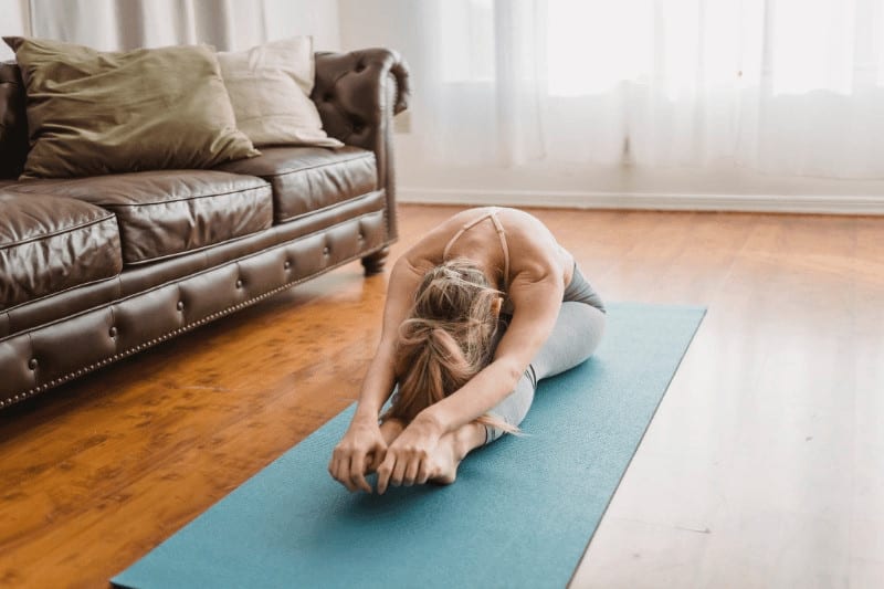 woman doing the seated forward bend pose