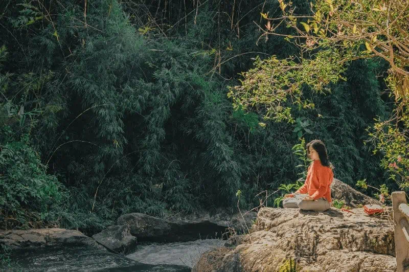woman sitting in a green environment finding her spirituality