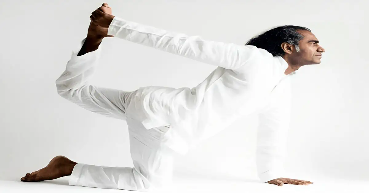 man in white outfit performing tiger pose in a white background