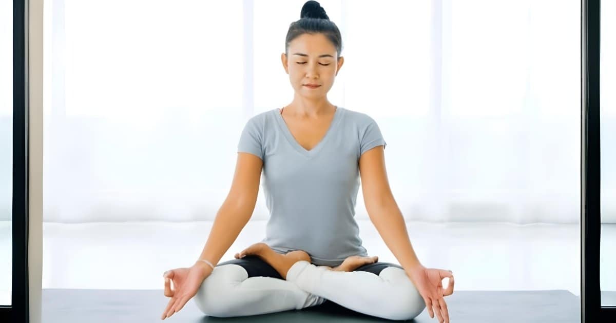 Mature woman doing yoga in lotus position on mat · Free Stock Photo