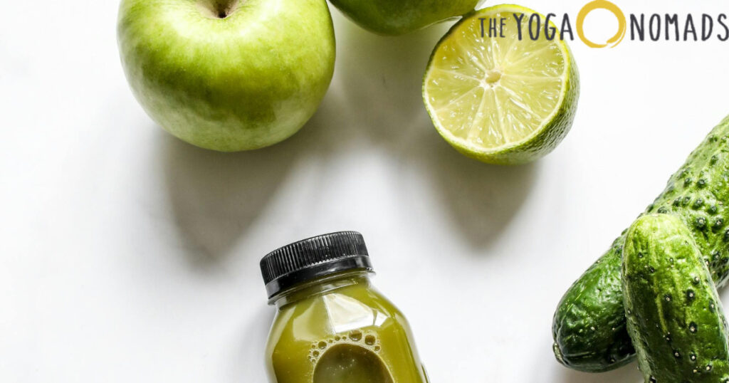 The image shows a selection of fresh, health-focused foods placed on a white surface. Items include a green apple, half a lime, a bottle of green juice with a black cap, and several cucumbers. These vibrant, nutrient-rich ingredients emphasize the importance of an anti-inflammatory diet for supporting joint wellness. Incorporating such foods into daily meals can contribute to reducing joint pain and improving overall mobility.